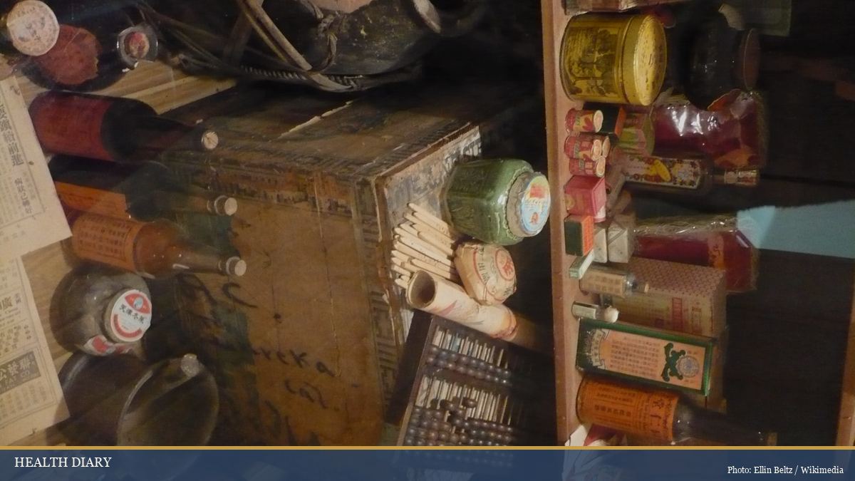 Traditional Chinese apothecary shelves with dried herbs in labelled jars and tins