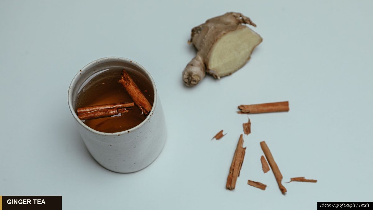 Golden ginger tea steeping in a glass cup with fresh ginger slices