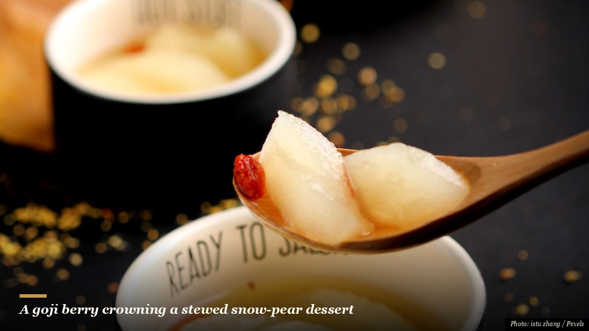 Small black bowls of traditional stewed snow pear dessert soup topped with a goji berry