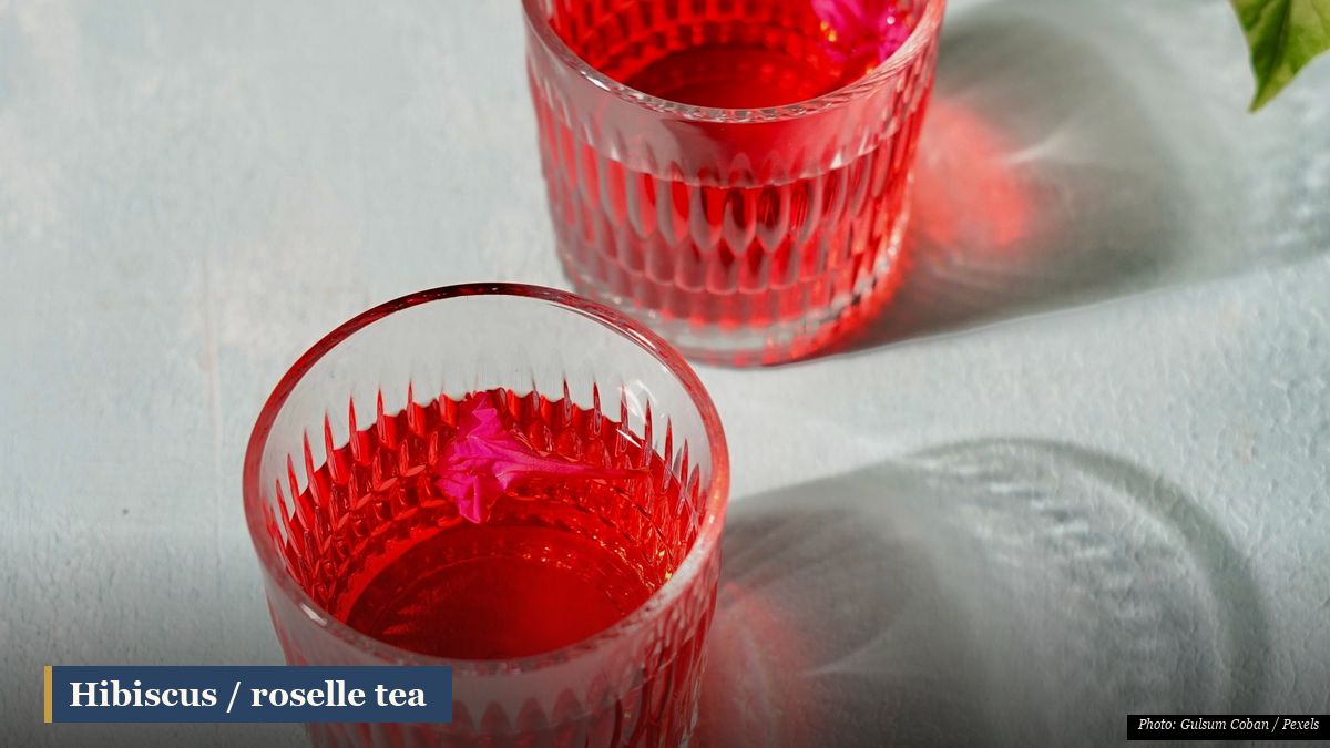 Ruby-red hibiscus roselle tea poured into a glass, a tart cooling herbal infusion