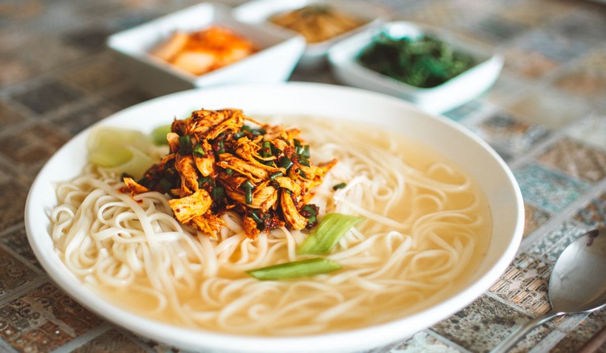 Korean-style Asian chicken soup served in a white bowl with chopsticks, reminiscent of Sam Gye Tang tradition