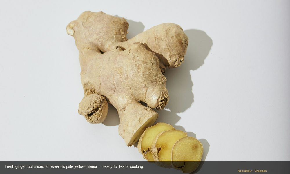 Sliced fresh ginger root showing pale yellow interior ready for tea preparation