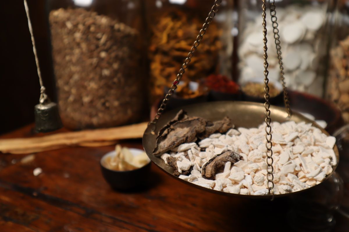 Dried tonic root pieces on a black plate, a traditional Chinese tonic