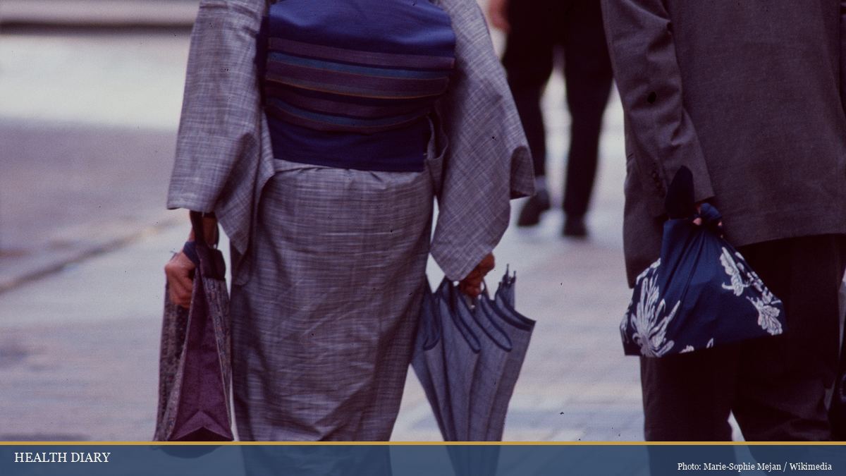 Elderly Japanese couple in traditional kimono walking together in a quiet city street