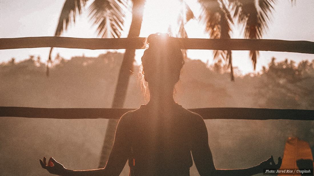 Woman sitting cross-legged in silent seated meditation indoors