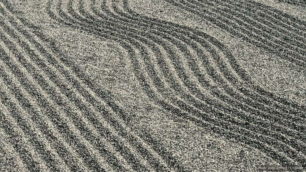 Wave patterns raked into the gravel of a Japanese zen garden