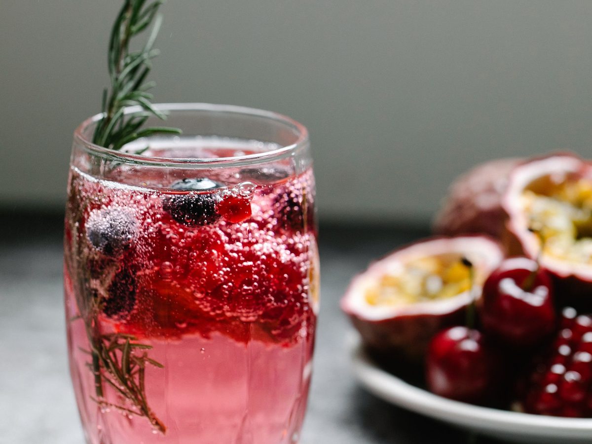 A glass of vivid ruby-red omija berry tea, showing the characteristic deep crimson color produced by cold-steeping dried Schisandra chinensis berries overnight