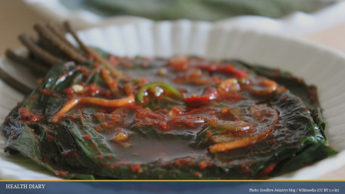 Kkaennip-kimchi seasoned Korean perilla leaves stacked in a small dish with chili paste topping