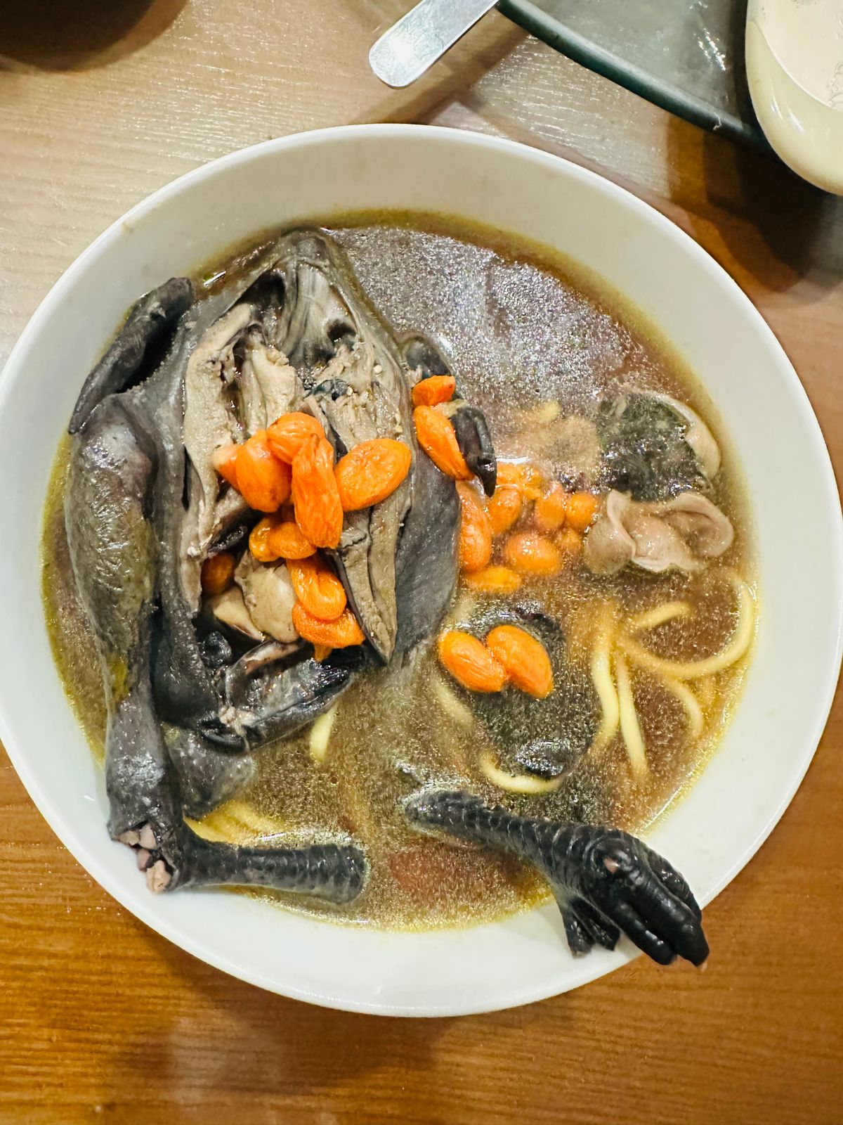 A pot of clear tonic broth simmering with pale medicinal ingredients
