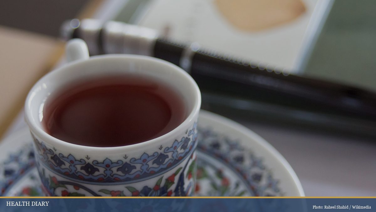 Patterned Korean teacup of warm omija five-flavor berry infusion on a writing desk