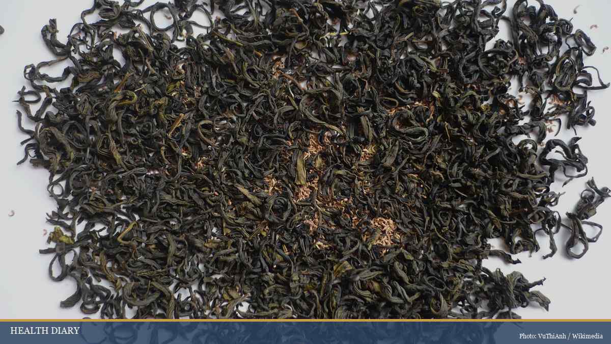 Dried Vietnamese lotus tea leaves spread on white surface ready for evening brewing
