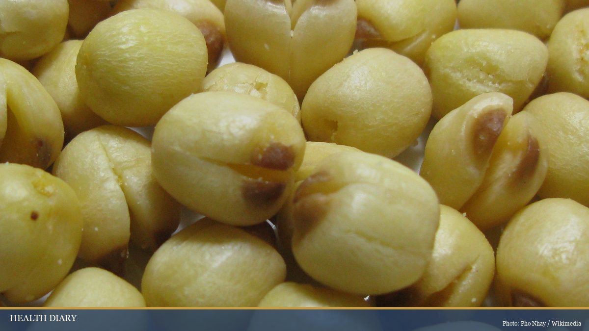 Pile of dried Vietnamese lotus seeds showing yellow husks and embryo notches close up