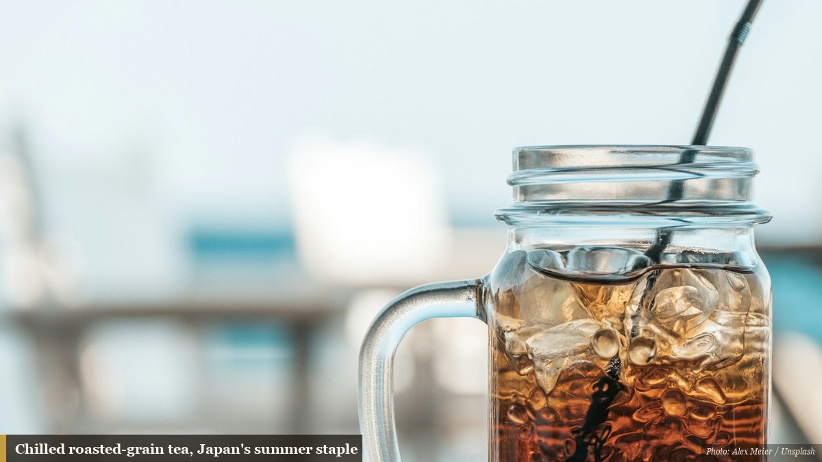 Glass jar of chilled amber tea with ice on a bright summer table