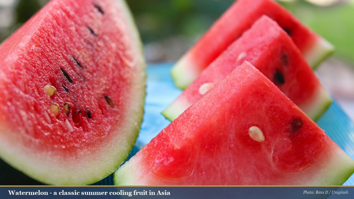 Fresh watermelon slices on a blue mat, a classic summer cooling fruit in Asia