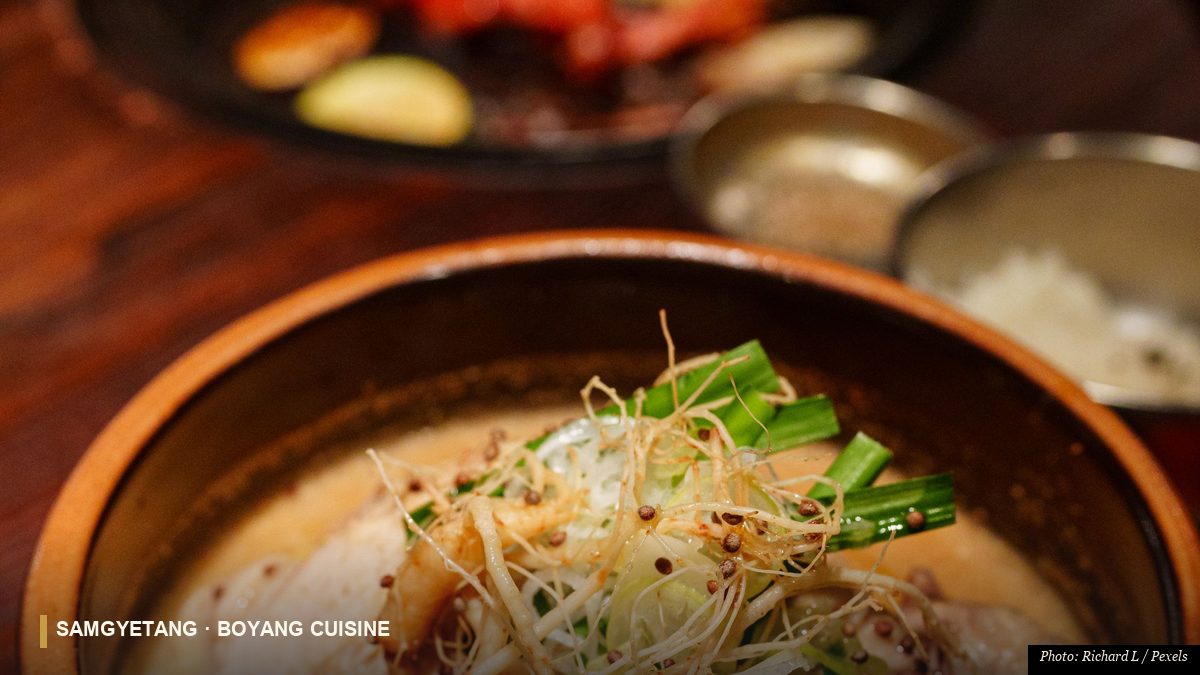 Korean samgyetang ginseng chicken soup in a clay pot garnished with scallions and jujube