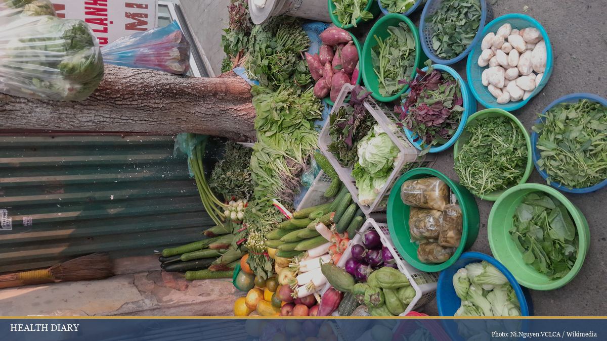 Fresh Vietnamese vegetable stall in a Hanoi village showing herbs and greens in baskets