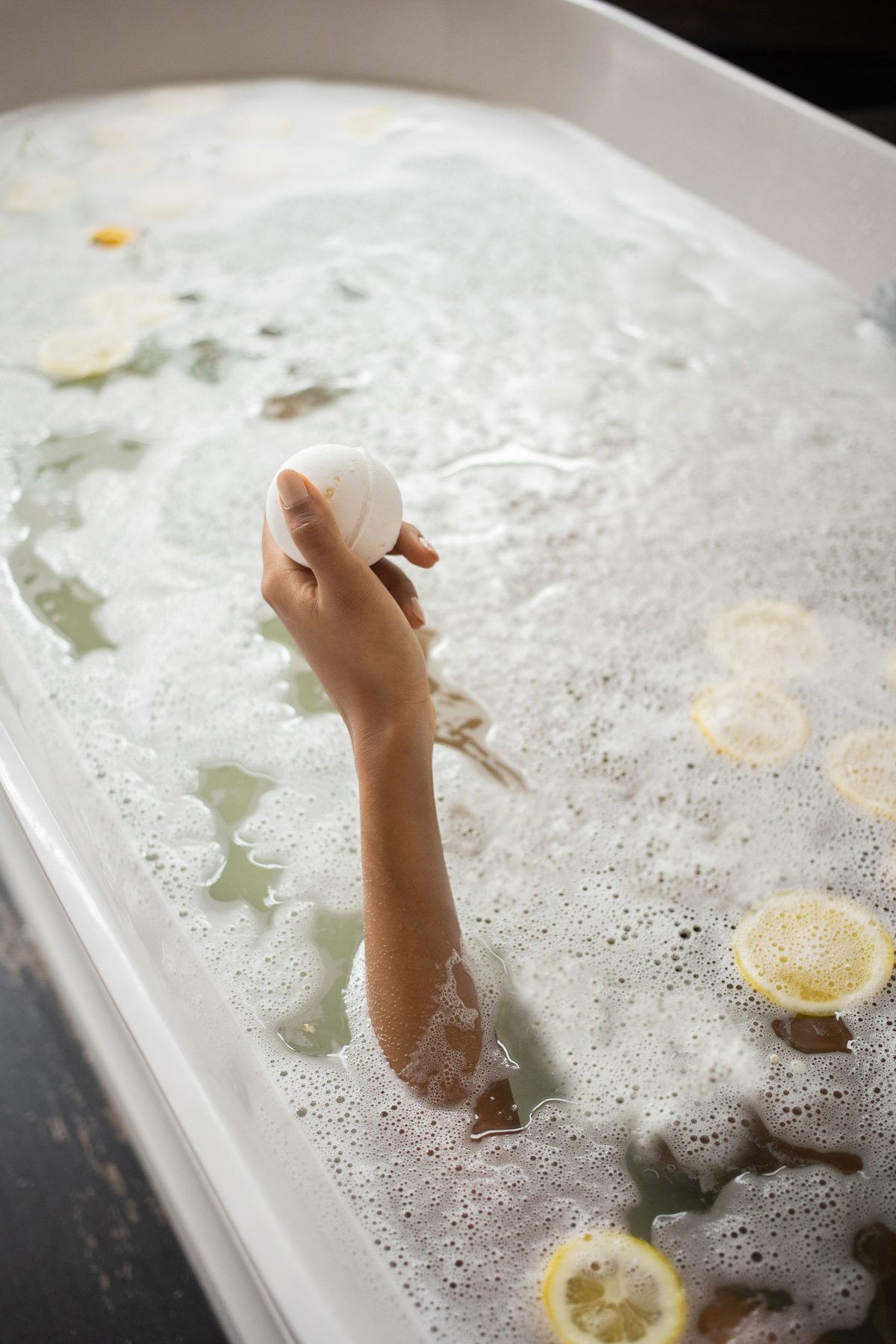 Citrus slices floating in warm water in a bathtub, evoking the Japanese yuzu-yu winter solstice bath tradition